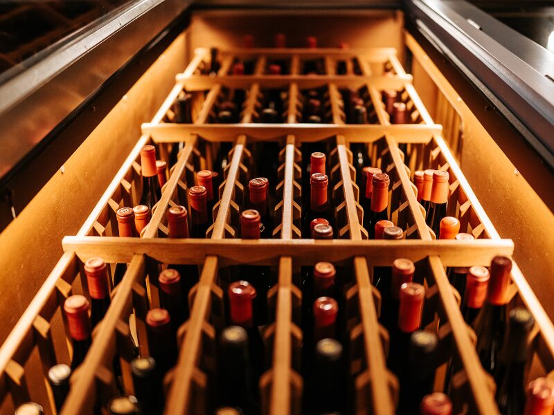 Wine bottles aging in a cellar rack