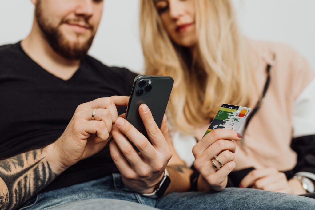 Couple making a rewards purchase with phone and credit card